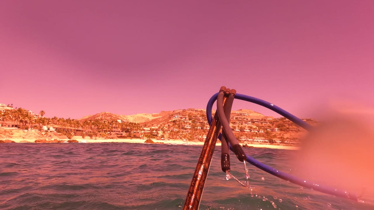 Rope and rigging near waterline with coastal hills