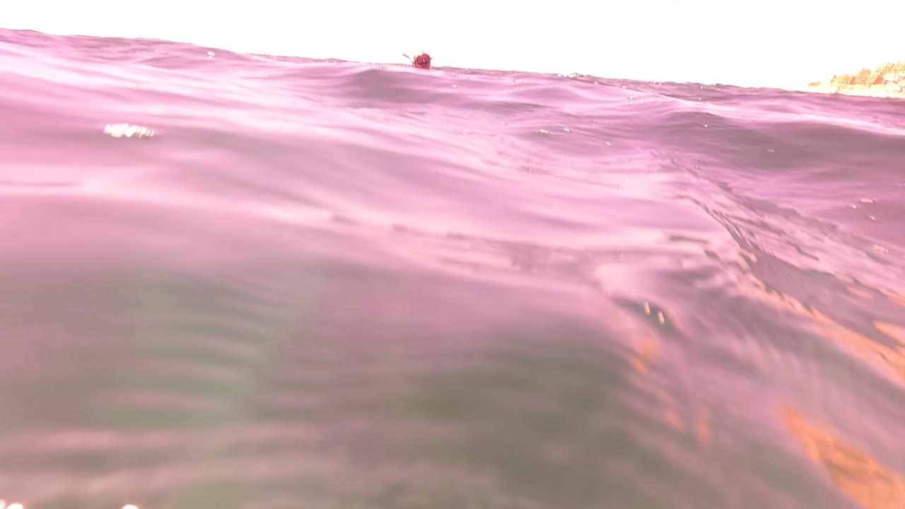Low pink ocean swell with overexposed horizon edge