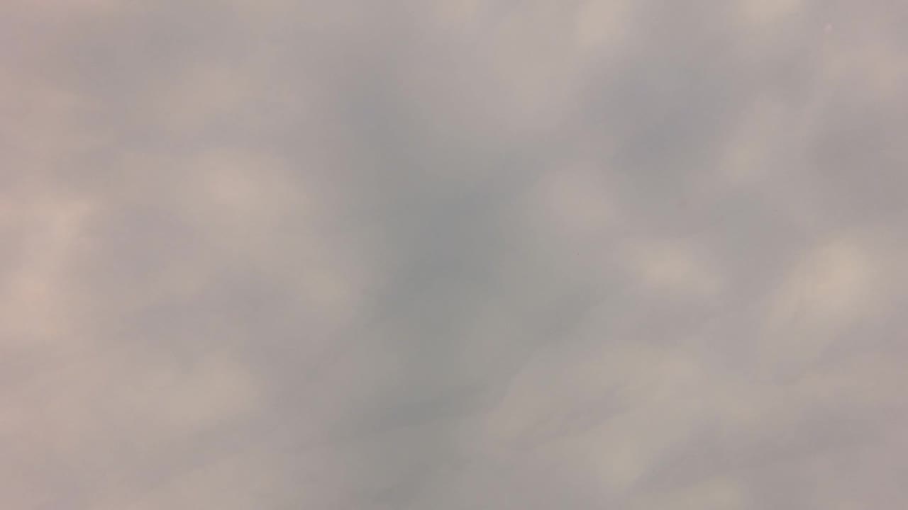 At 0:02, only the defocused San Jose del Cabo water surface is visible, with darker ripple shadows spreading through a pale gray field and no visible people.