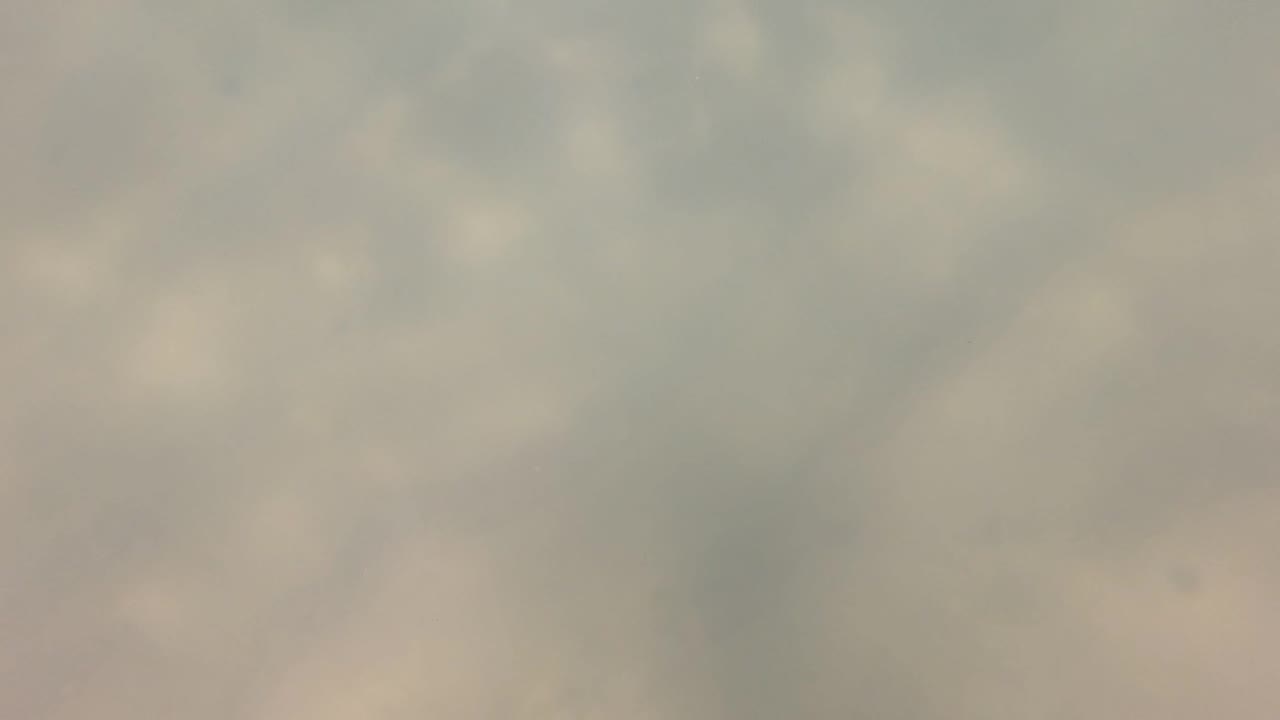 Early frame from San Jose del Cabo underwater footage showing pale gray-green cloudy water with soft light patches and no visible people.