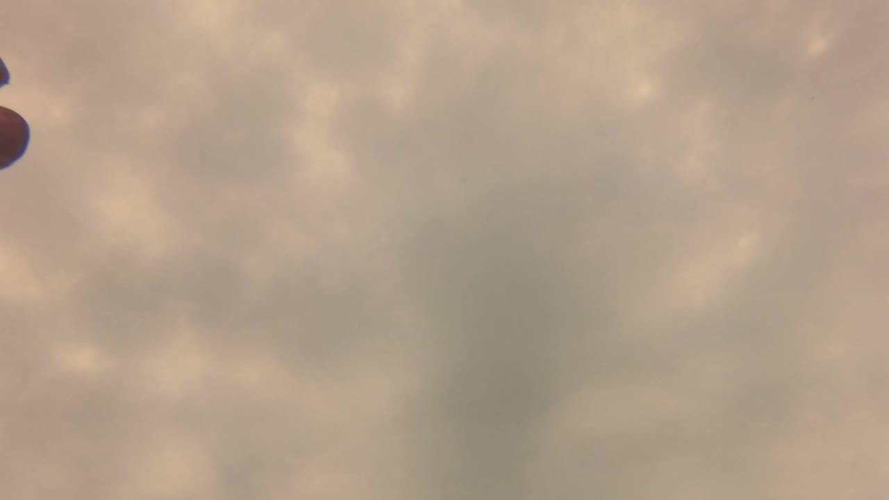 A partial hand enters from the left edge over clear rippling water in San Jose Del Cabo, with soft caustic light and muted beige-green color.