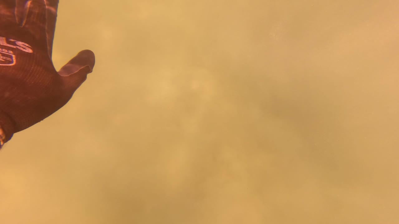 Raised gloved hand against dense orange-yellow haze