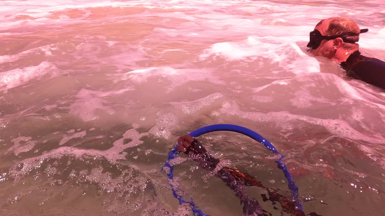 Swimmer near surface foam with blue ring gear below