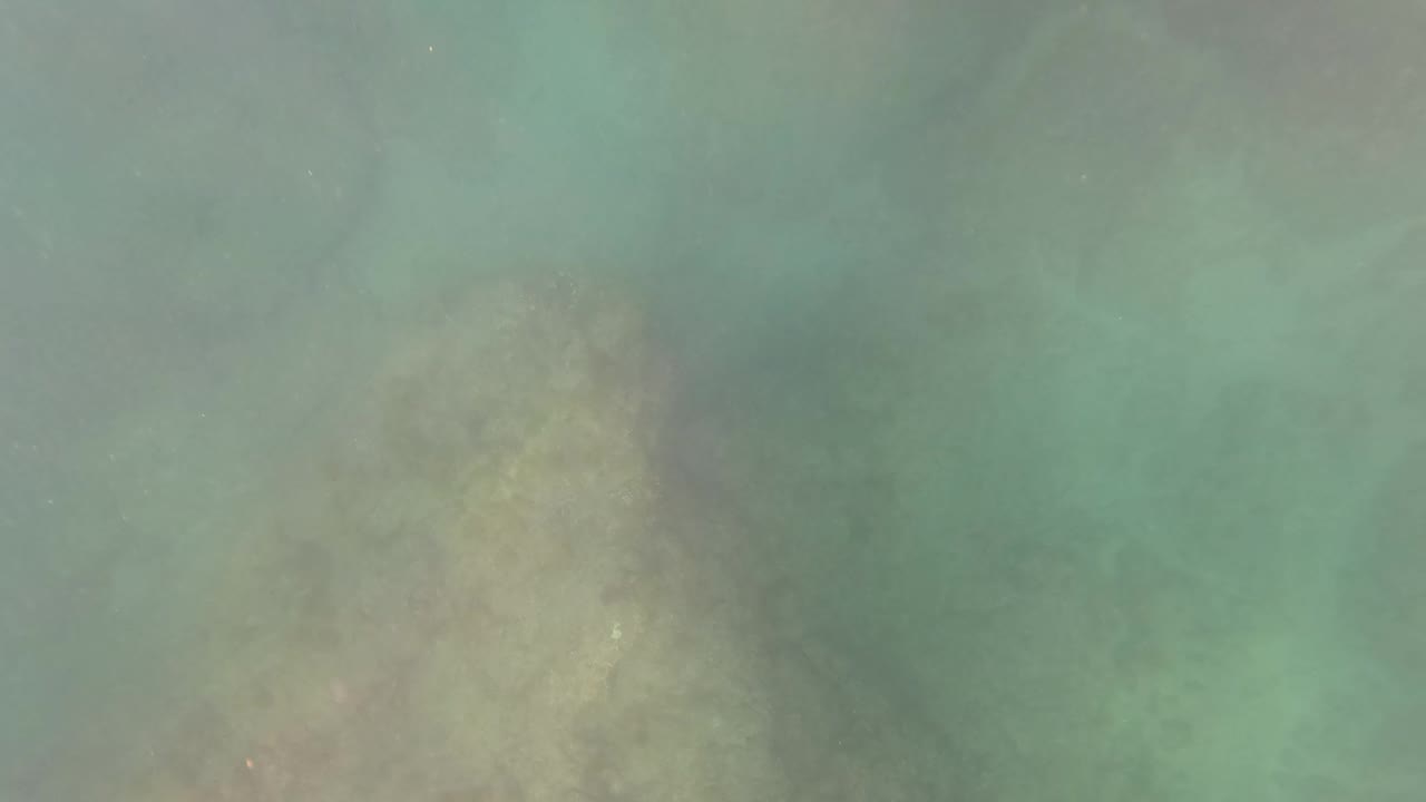 Clear water over uneven rocky seabed