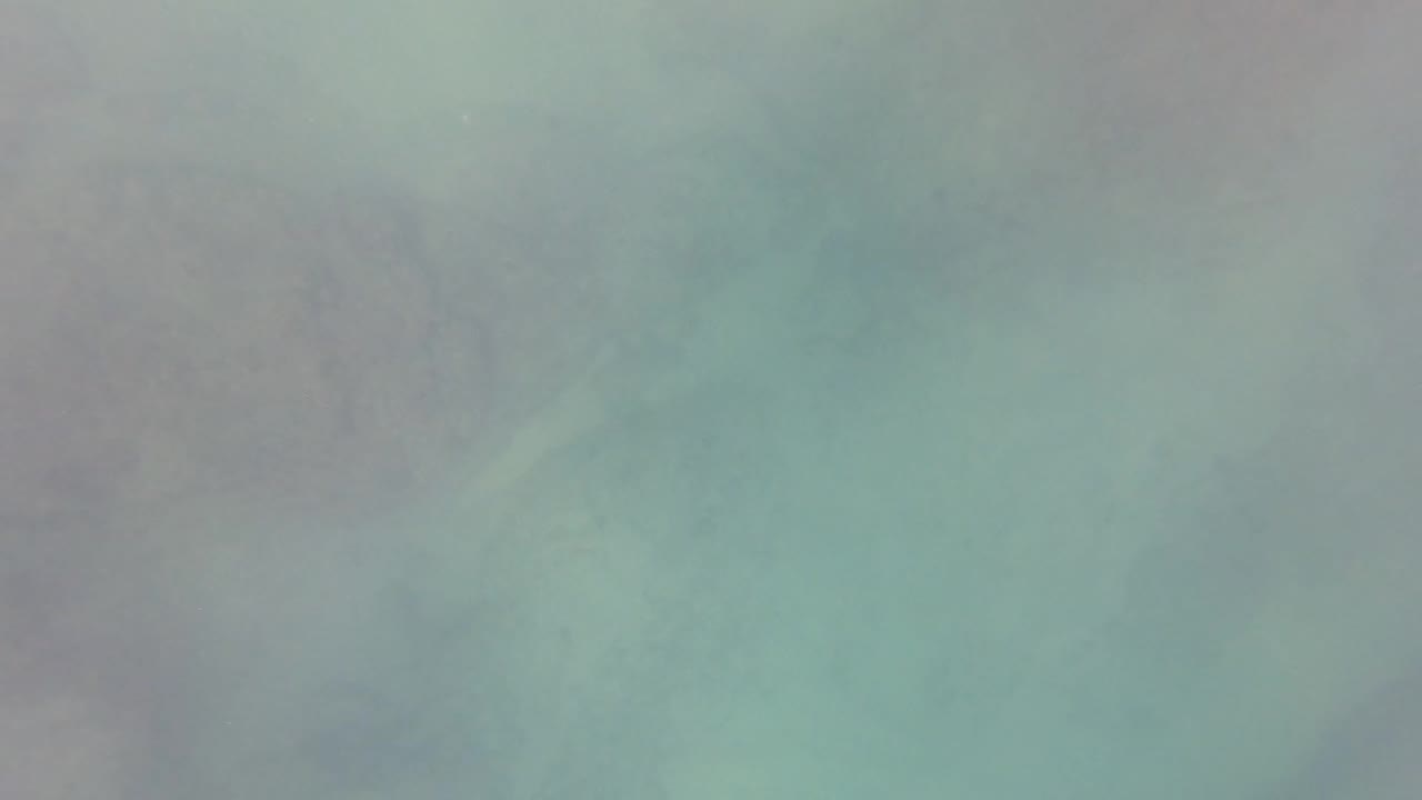 Soft blue-green underwater frame from San Jose del Cabo with blurred seabed texture behind the water haze and no visible people.