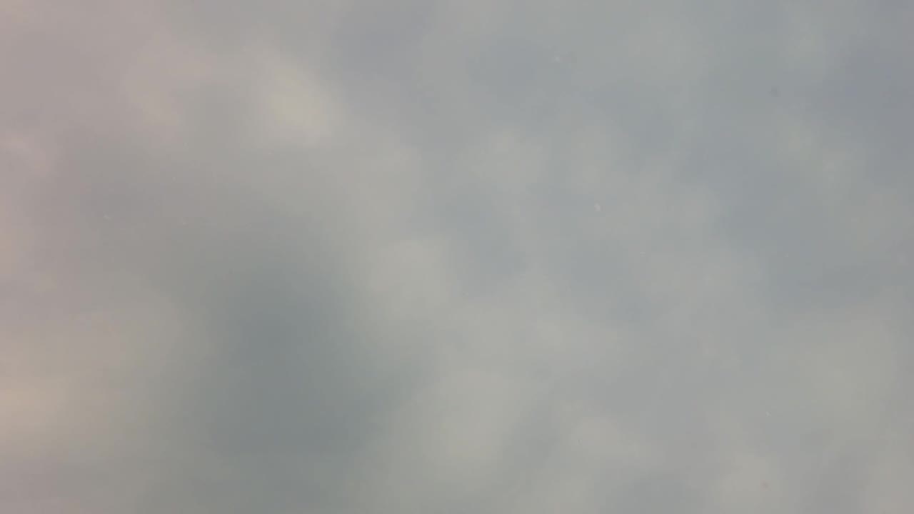 Diffuse blue-gray cloud shapes spread across the San Jose Del Cabo sky one second in, with the frame still fully abstract and no visible people.