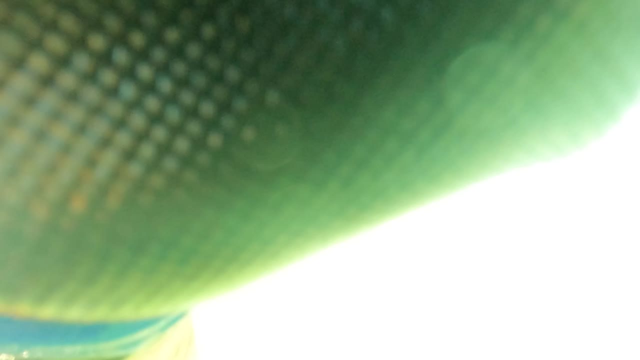 A close view of fishing netting sits against bright surface glare and green-blue water in San Jose Del Cabo, with no visible people.