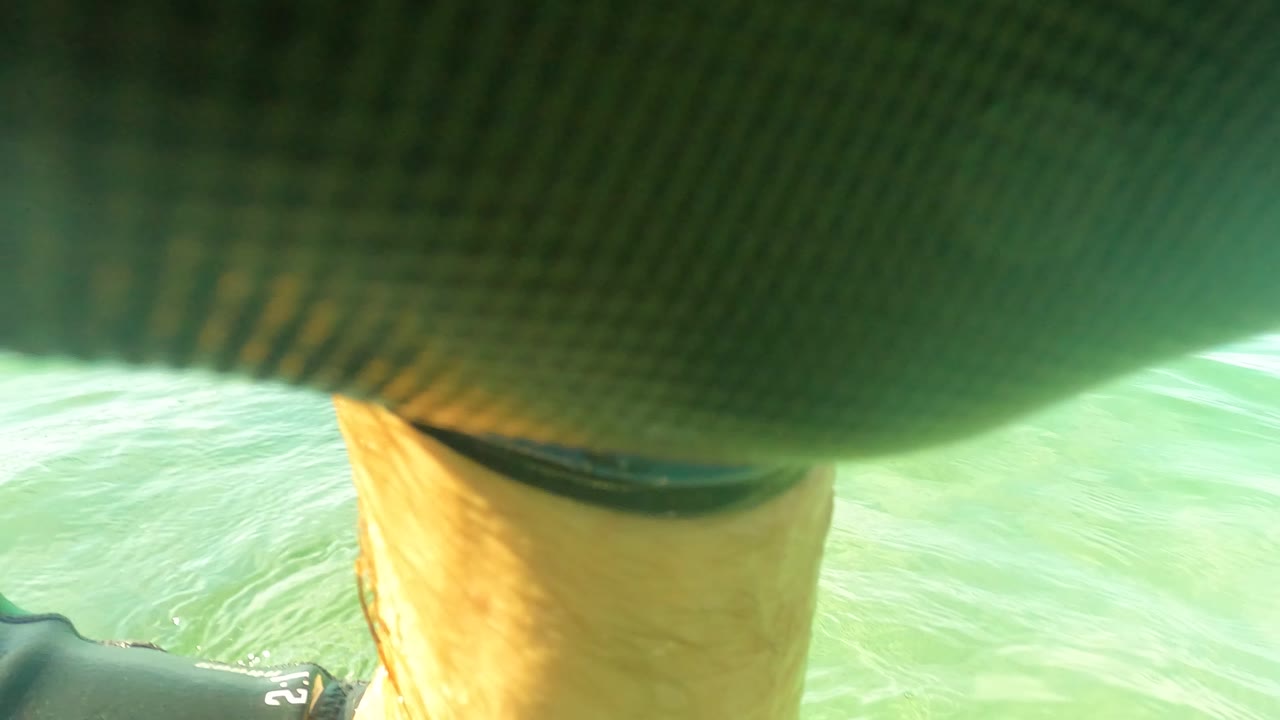 Fishing netting cuts across the top of the frame while tan submerged material and pale green water appear below in San Jose Del Cabo, with no visible people.
