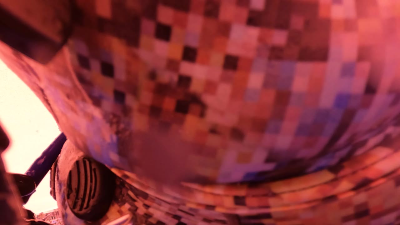 Close-up from San Jose Del Cabo, Mexico showing patterned patient clothing and part of a breathing apparatus tube under warm pink light.