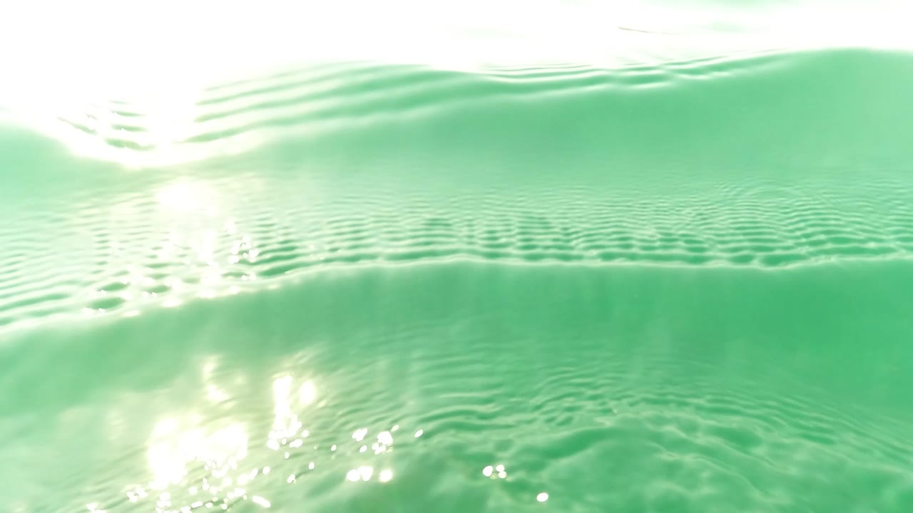 Bright water surface seen from below with sun reflections