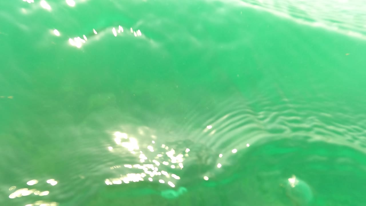 Bright rippled ocean surface in San Jose del Cabo seen from underwater, with white light reflections and no visible people.