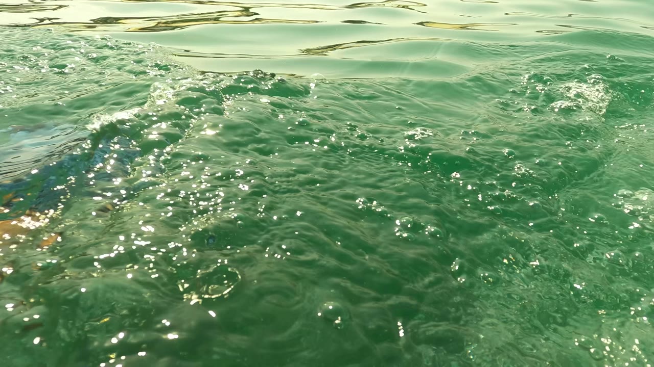 Close rippled ocean surface with bubbles and sparkle