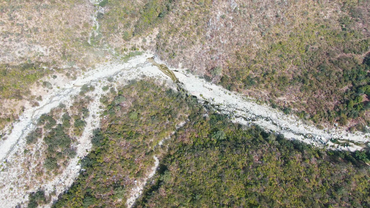 Overhead rocky wash bordered by scrub and grass