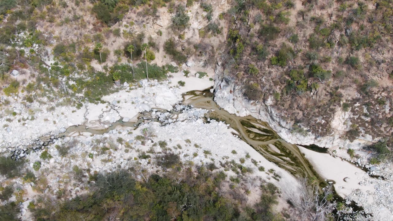 Third frame from above San Dionisio, Baja California Sur showing braided dark water lines across pale rock and scrub, with no visible people.