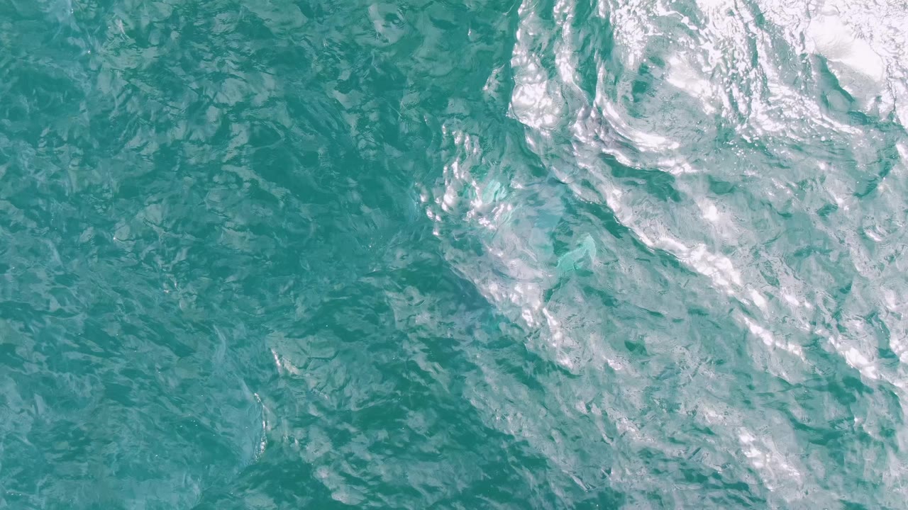 Choppy turquoise water with broad white foam and no visible shoreline or people.
