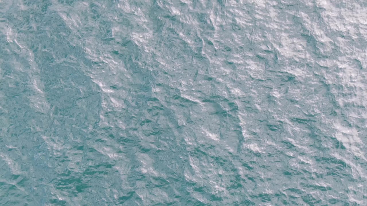 Blue-green ocean water with brighter ripple highlights.