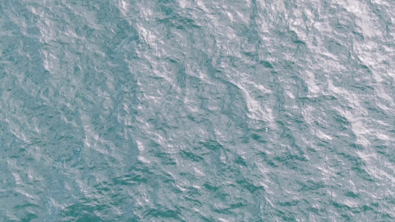 Rippled ocean surface at Shipwrecks, Baja California Sur, with pale streaks beginning to stand out against the turquoise water and no visible people.