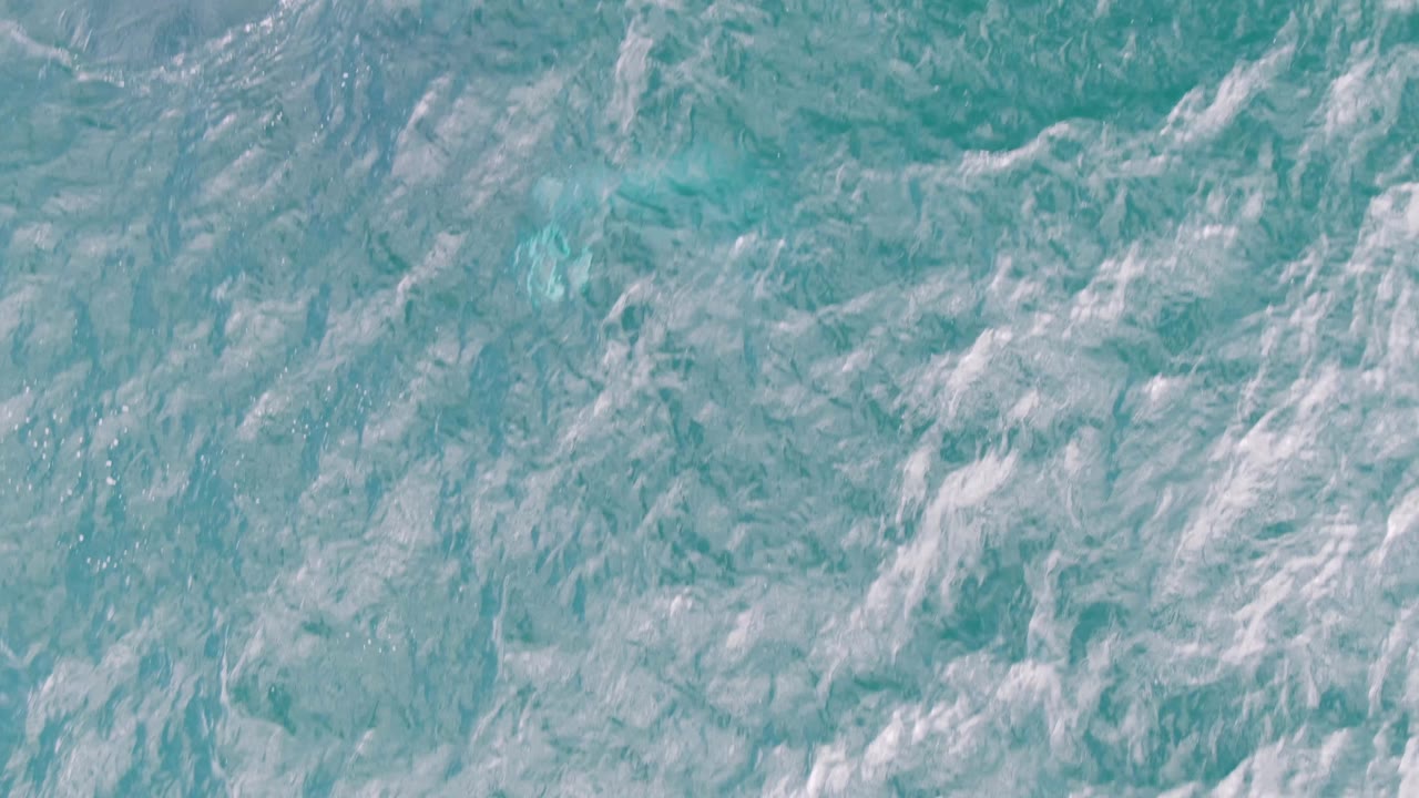 Turquoise ocean surface at Shipwrecks, Baja California Sur, showing thin white foam lines spread across the frame and no visible people.