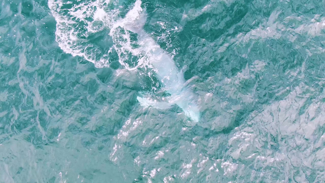 Turquoise ocean surface with white foam and no visible people.