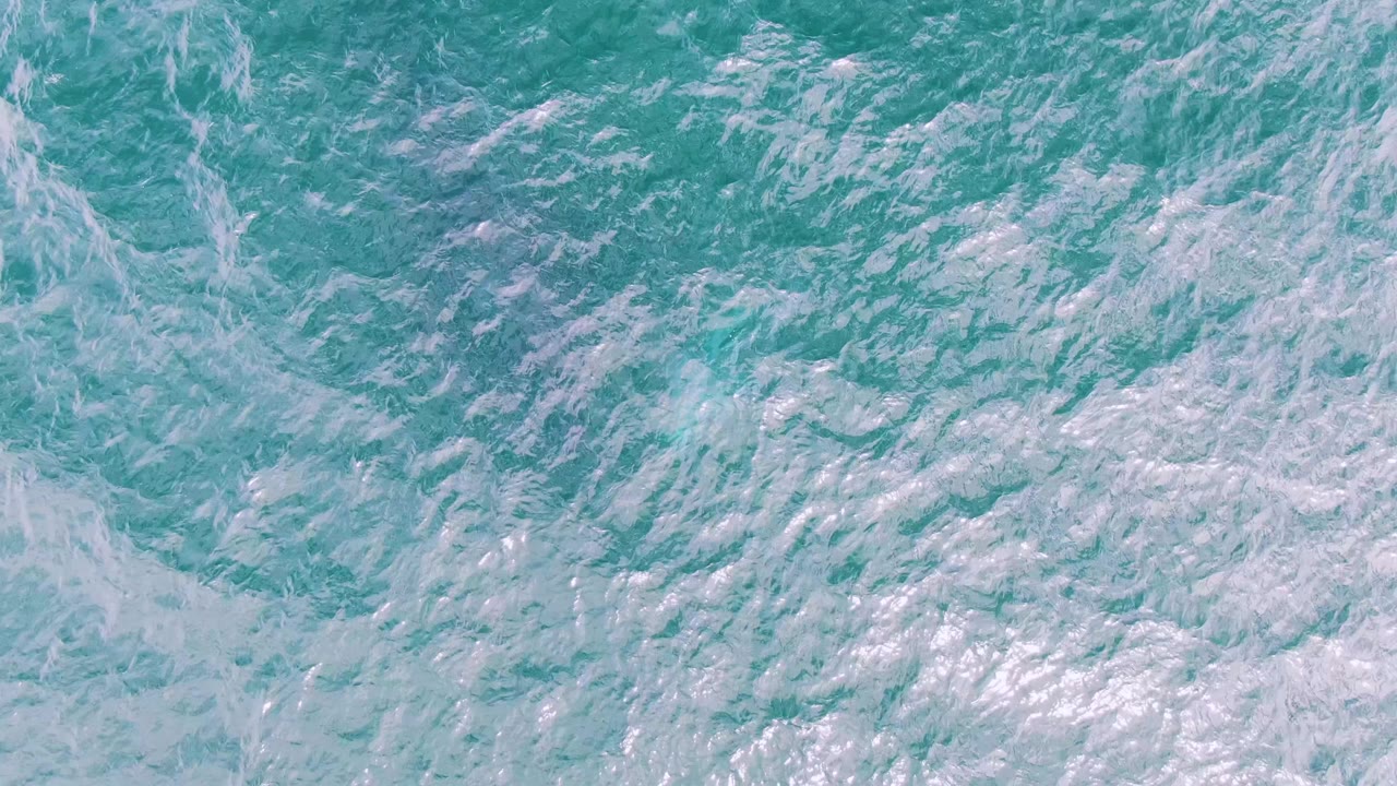 Churning blue-green water with foamy wave lines