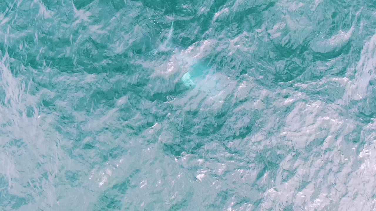 Foamy turquoise water with a small bright splash near the upper left.