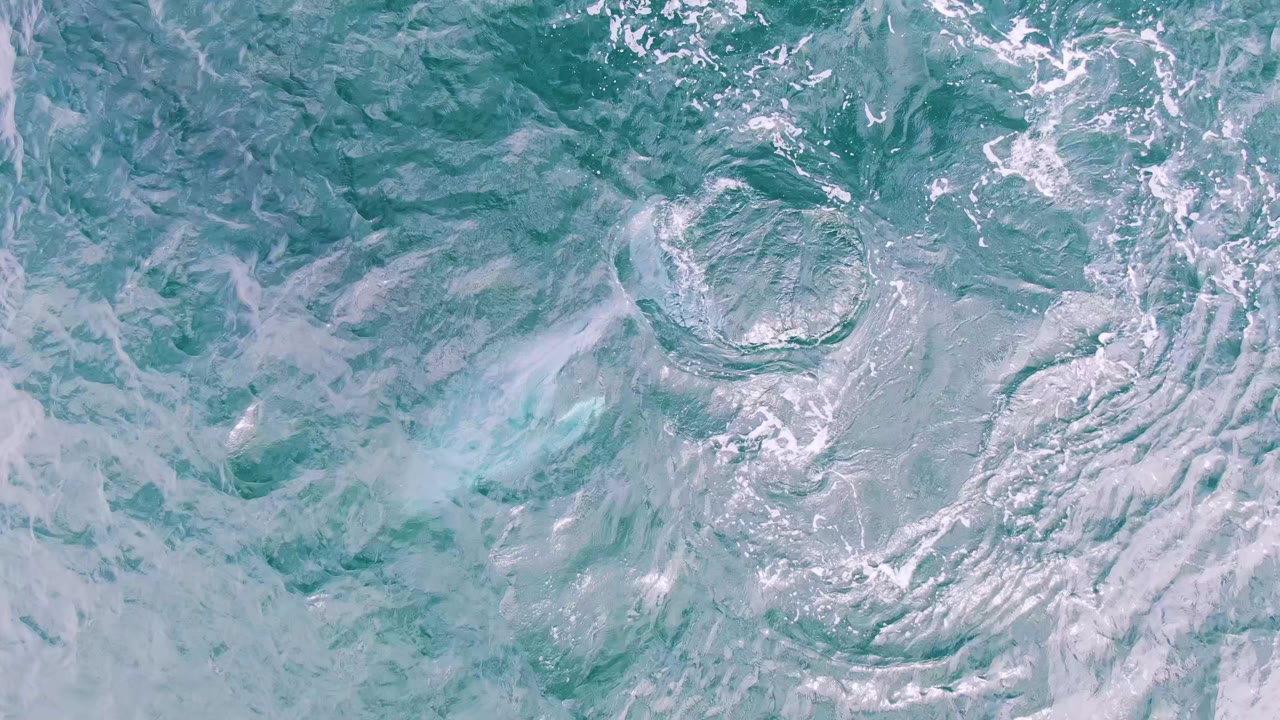 Textured turquoise water with circular wake where the whale has dived.
