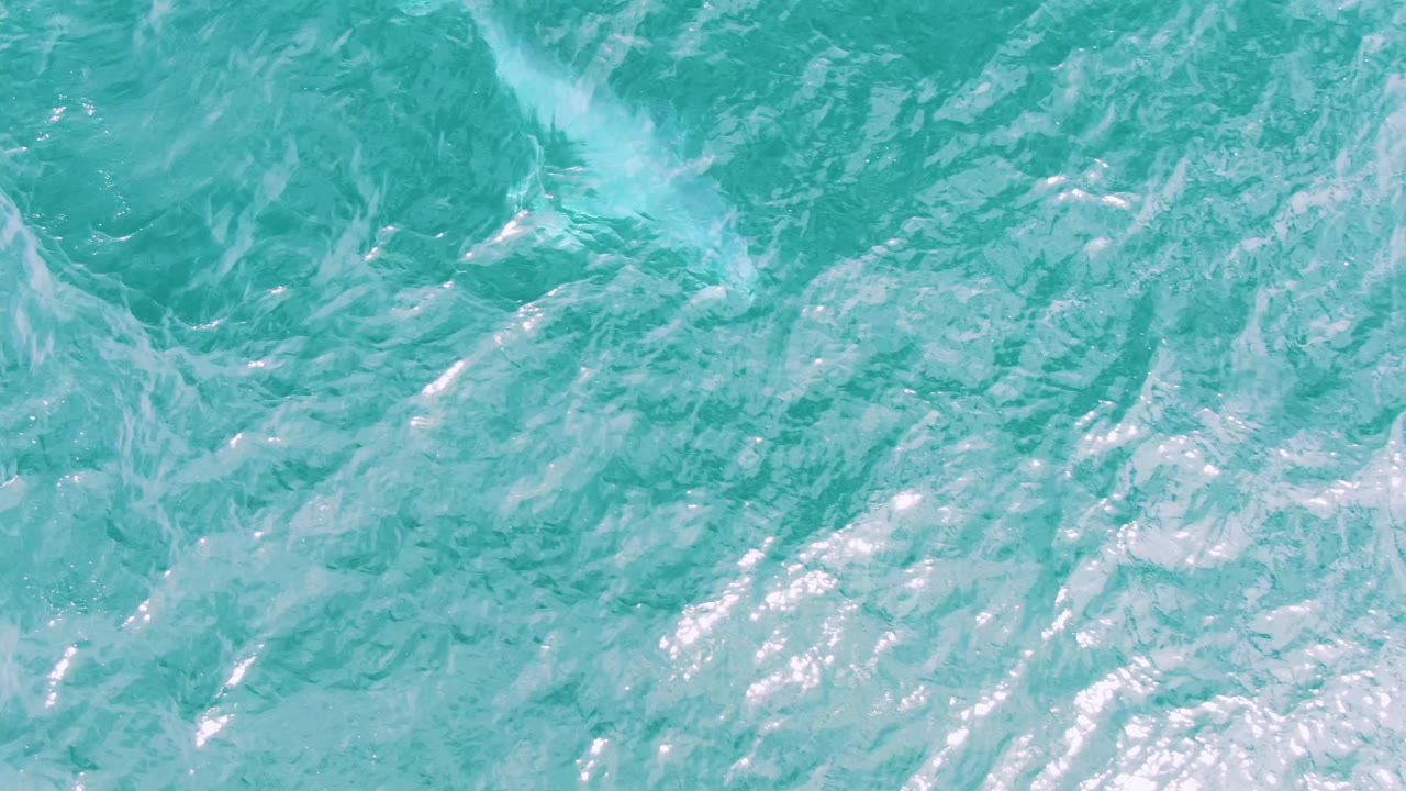 Overhead view of turquoise ocean water at Shipwrecks, Baja California Sur, Mexico, with white ripples across the surface and no visible people.