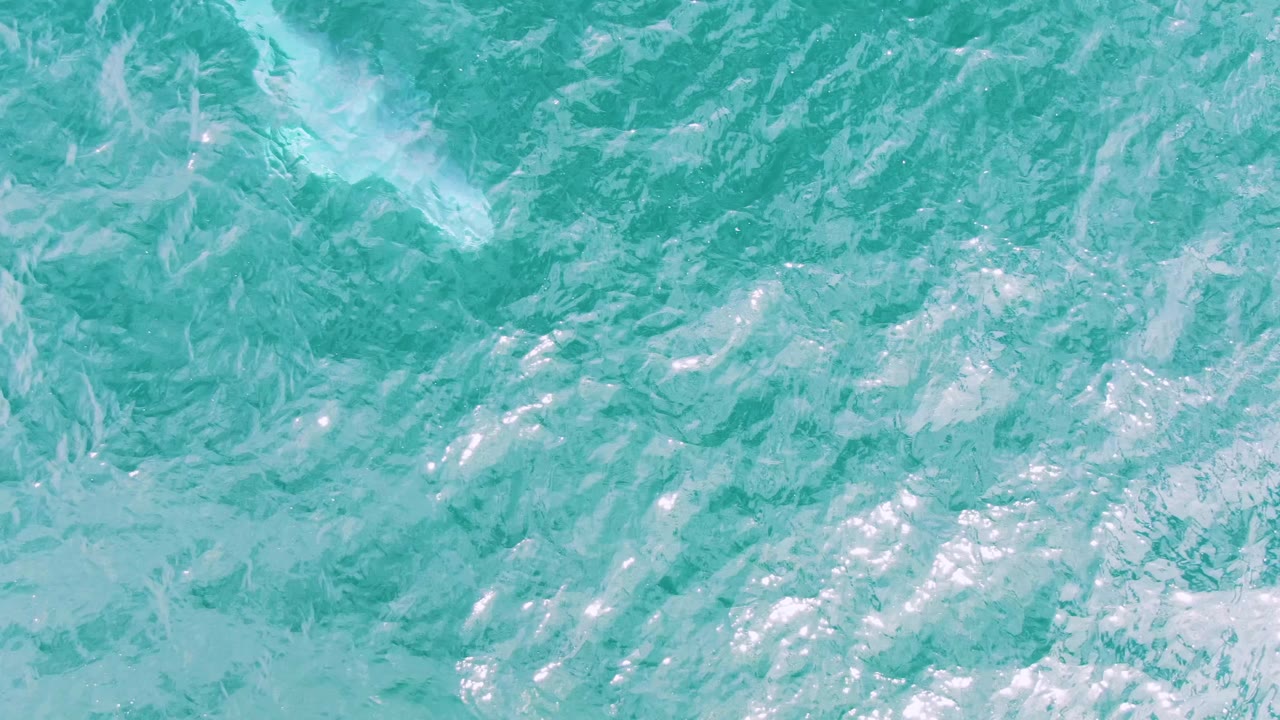 Turquoise ocean surface at Shipwrecks, Baja California Sur, Mexico, seen from above with pale streaks of foam and no visible people.
