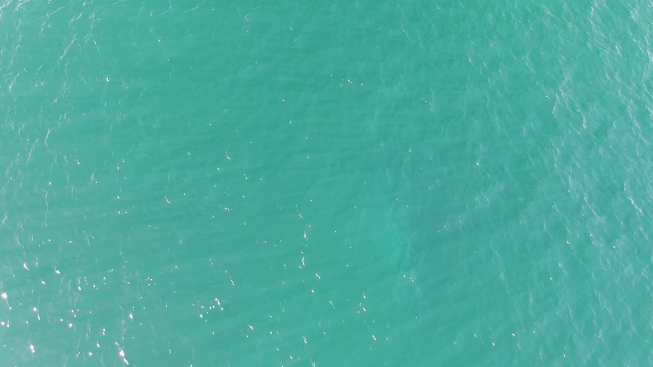 Open turquoise sea surface at Buzzards Beach in Baja California Sur remains frame-filling, with fine ripples, subtle shimmer, and no visible people or objects.