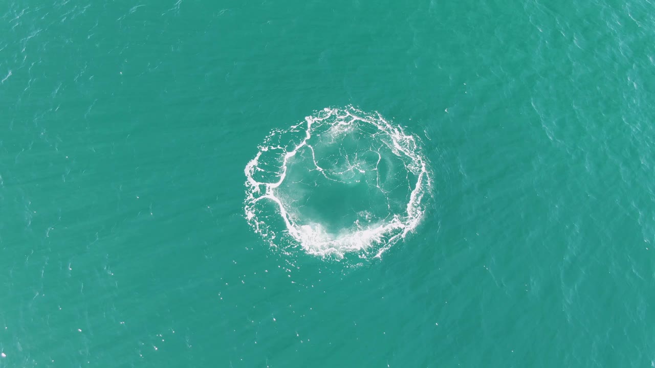 At Buzzards Beach in Baja California Sur, a white circular splash sits in turquoise ocean water with no visible people or shoreline.