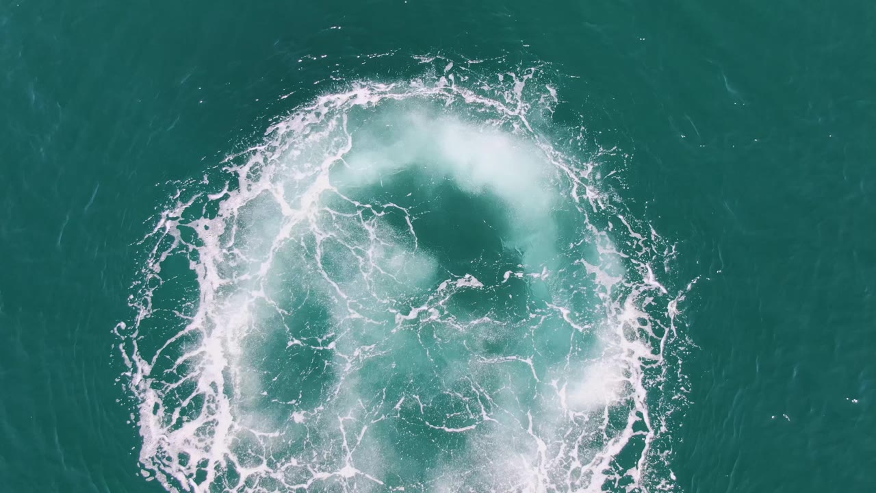 Foam arc curling around ocean vortex