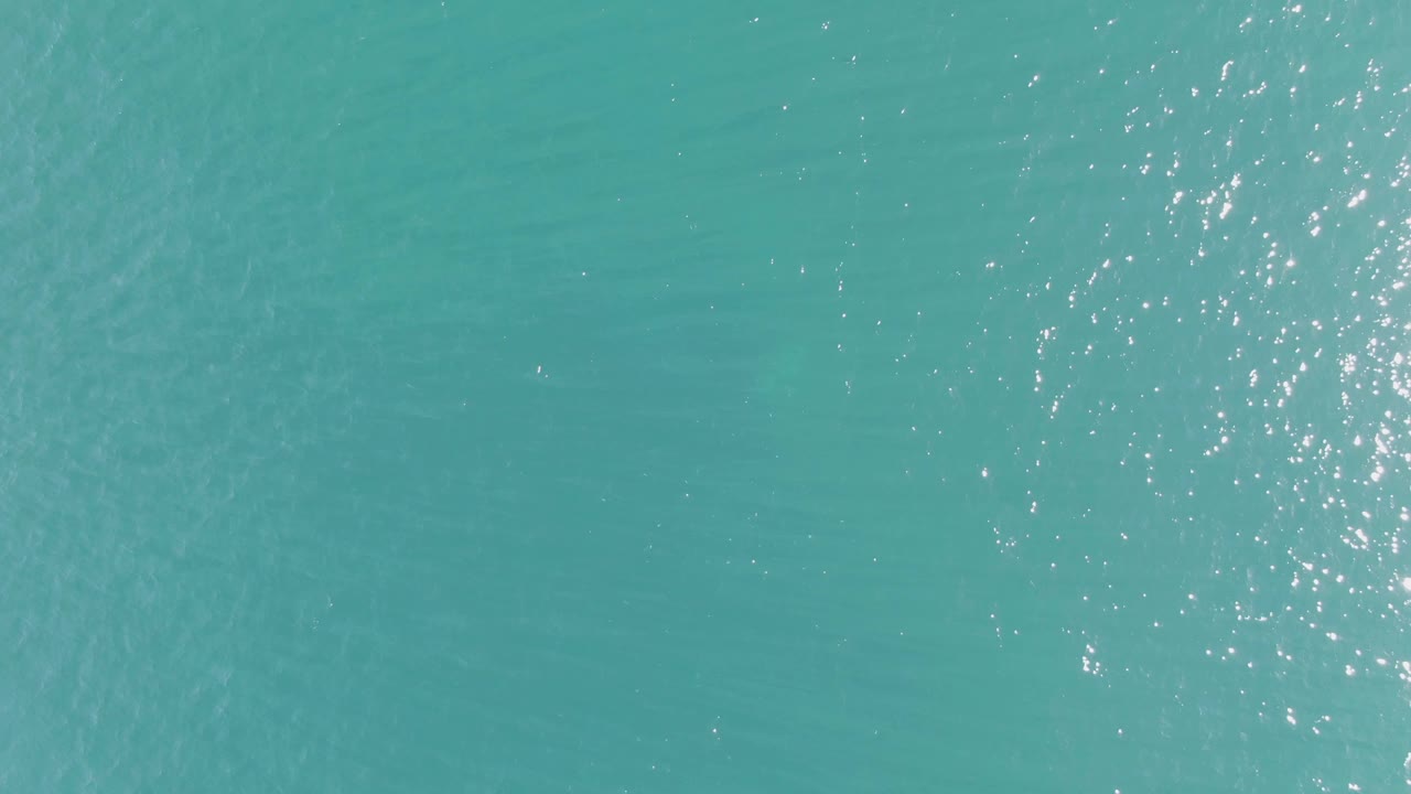 Turquoise ocean water at Buzzards Beach in Baja California Sur fills the frame with scattered sunlight reflections and no visible people.
