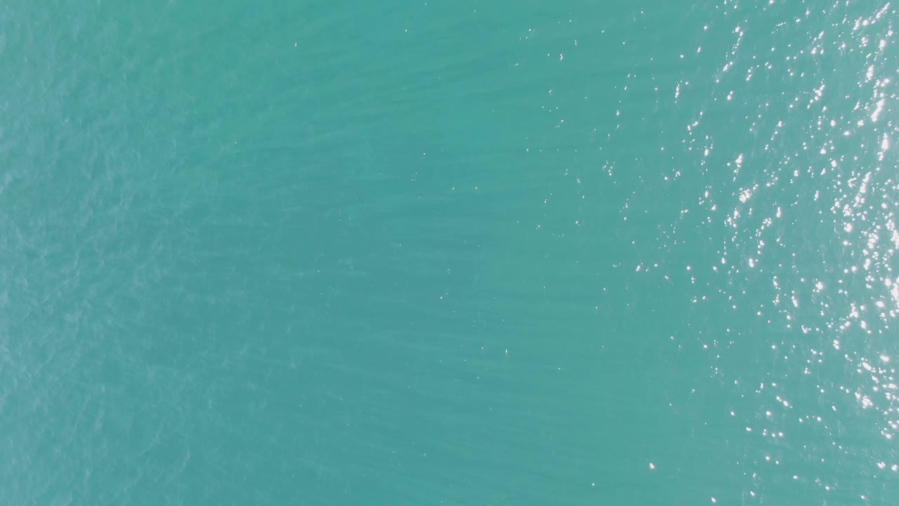 Blue-green ocean surface at Buzzards Beach fills the frame with fine ripples and concentrated sunlight reflections, with no visible people.