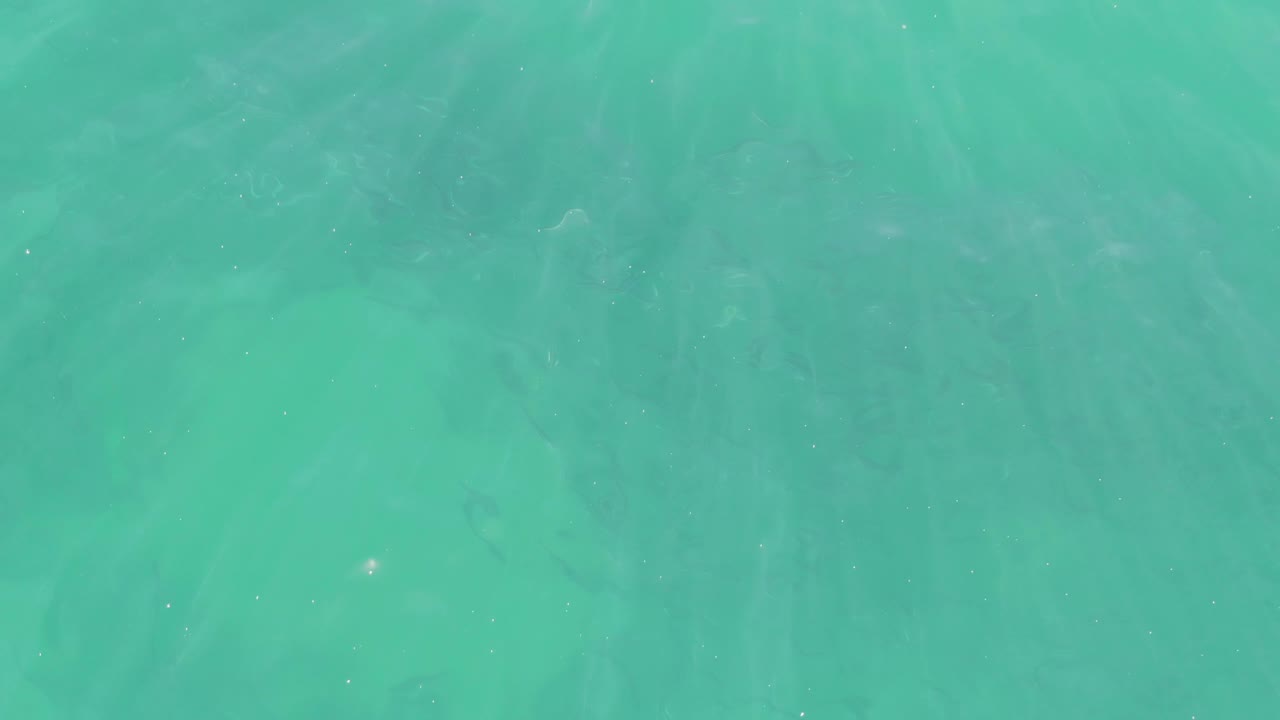 Turquoise seawater with darker seabed patches