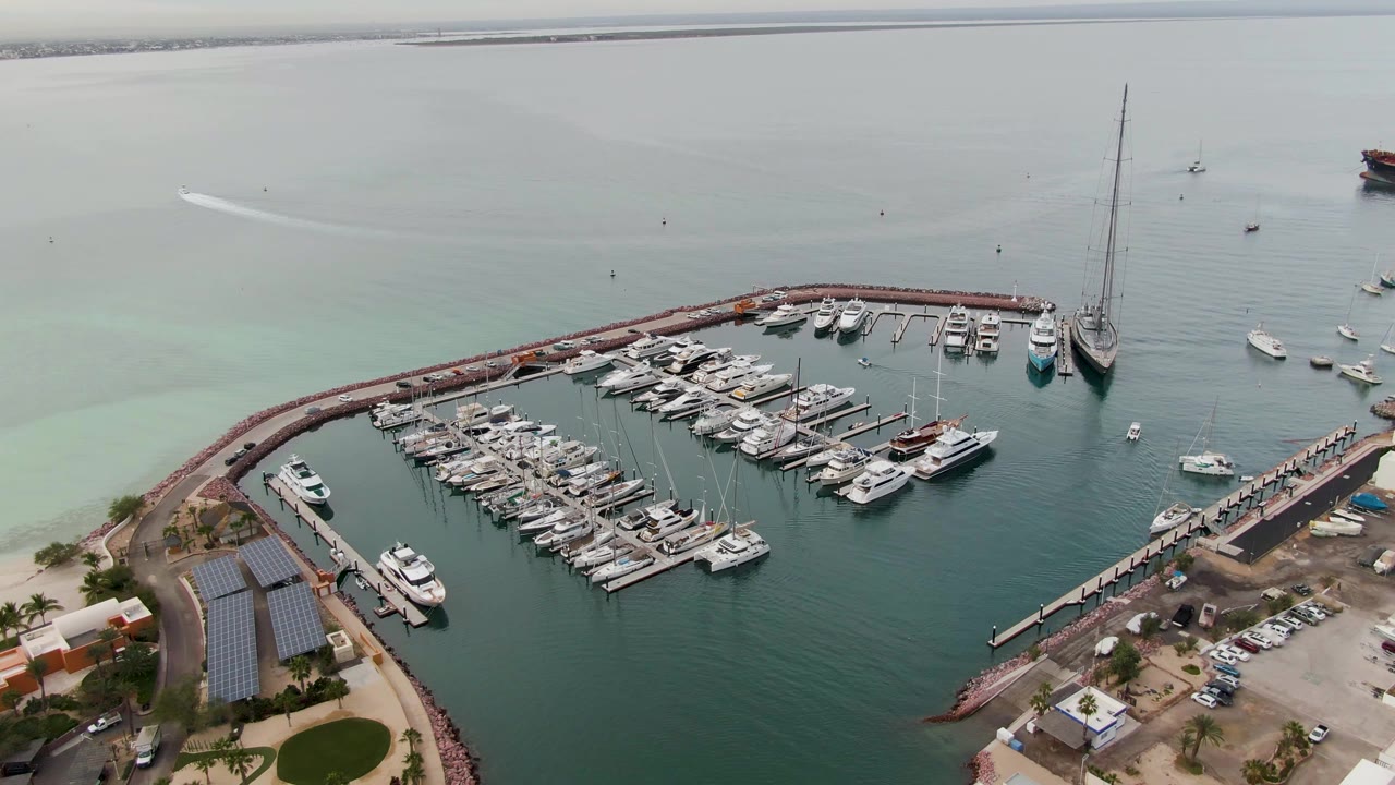 Aerial view of a marina with docked boats and pale turquoise water.