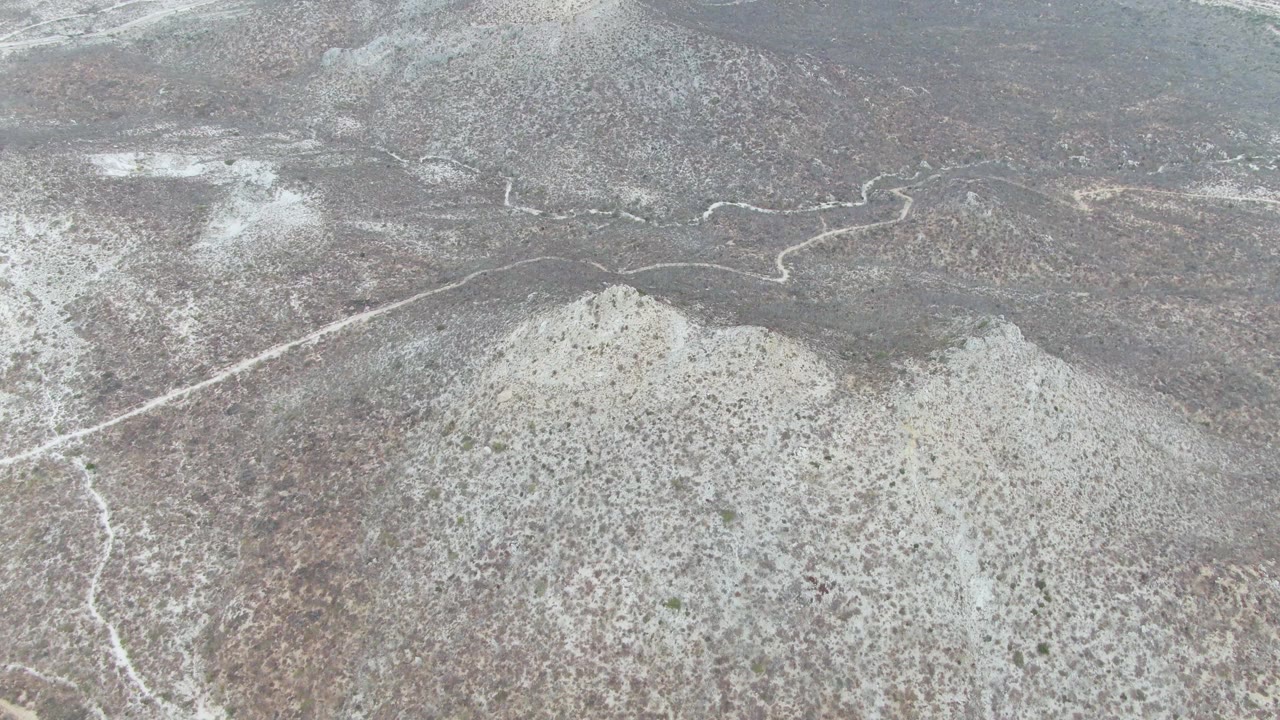 Snow-dusted hills with a winding pale road
