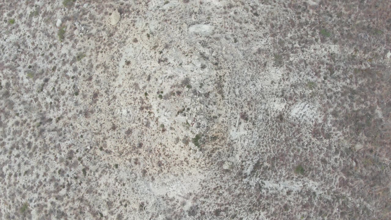 Aerial-looking frame from Punta Gorda Beach, Baja California Sur, showing pale textured terrain broken by darker ground marks and no visible people.