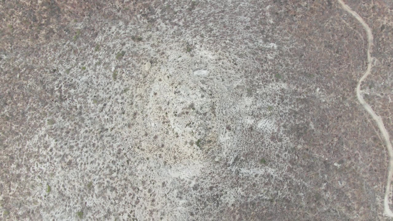 Aerial view near Punta Gorda Beach with a pale winding dry riverbed or path entering along the right side and no visible people.