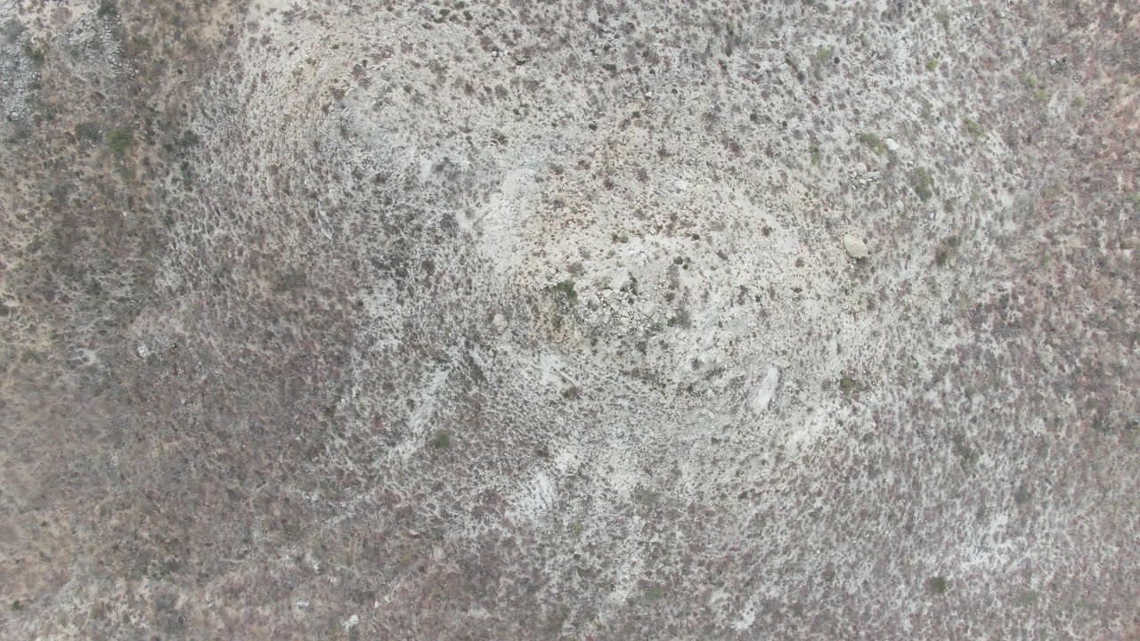 Midpoint frame from Punta Gorda Beach BCS showing a close overhead view of white foam across mottled stone, with no horizon and no visible people.