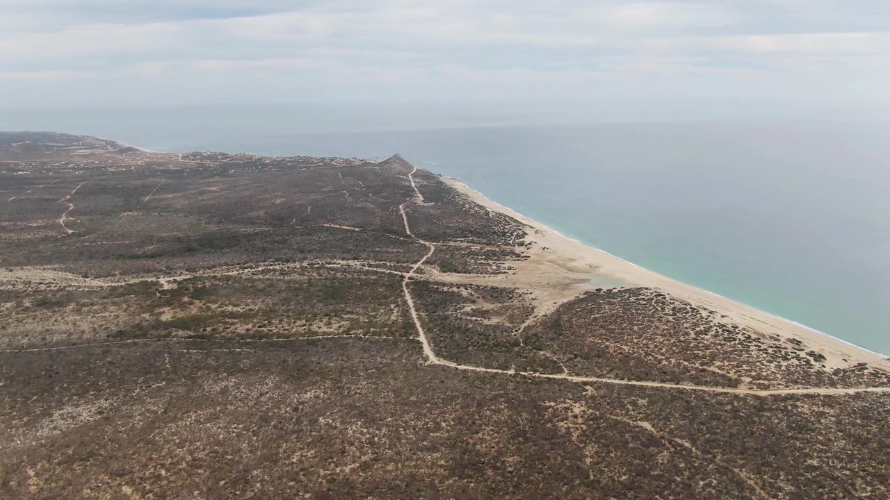 High aerial view of Punta Gorda Beach shoreline and sparse inland vegetation