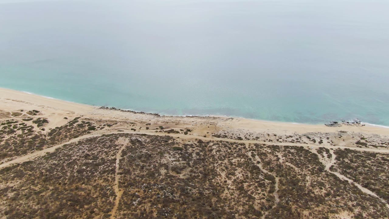 At two seconds, the aerial view shows more open pale water above the beach, with the dune paths and scrub patterns continuing across the lower half of Punta Gorda Beach.