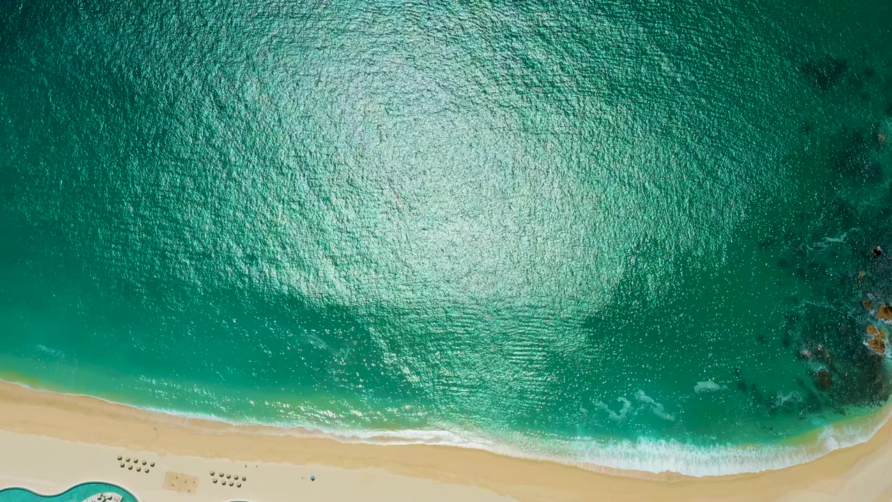 Bright rippled ocean above a sandy beach