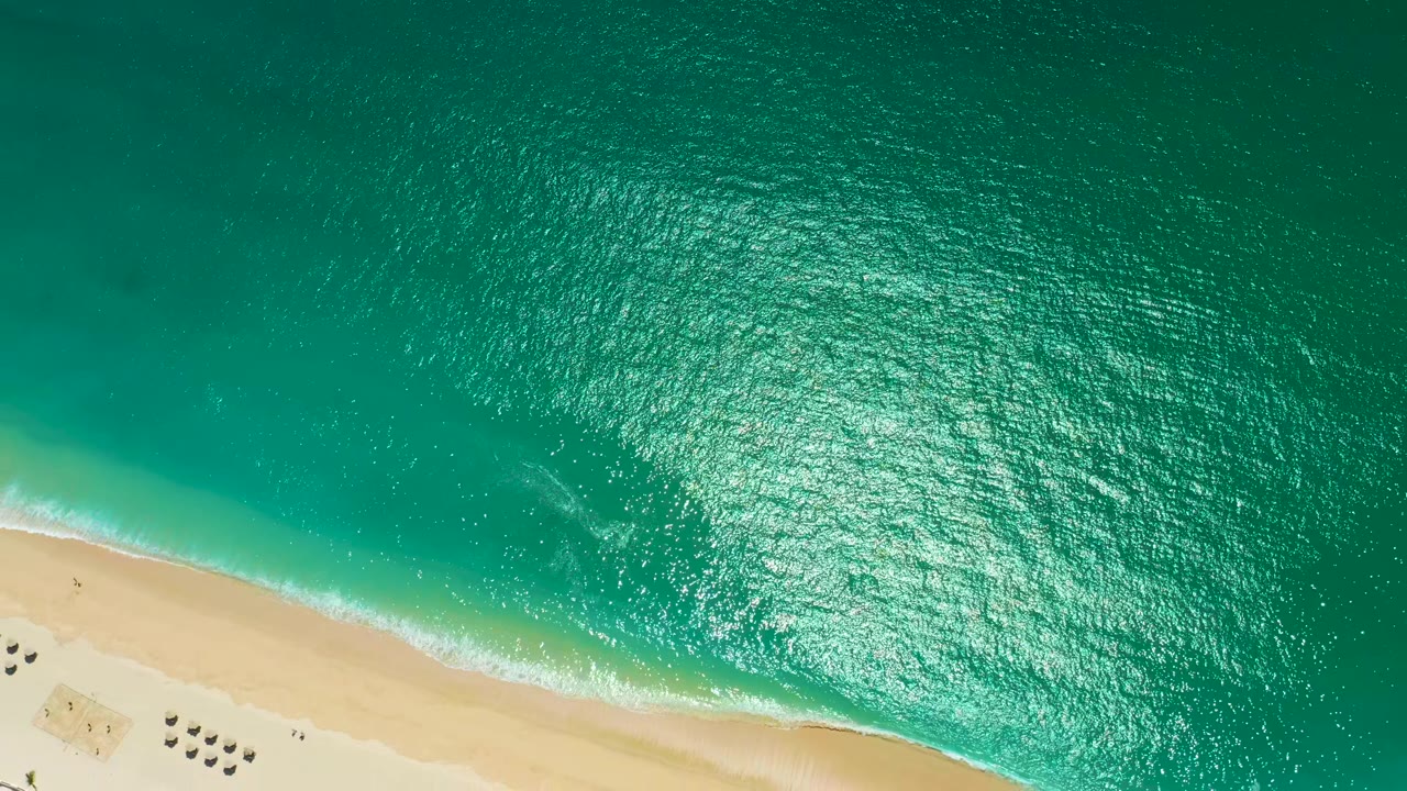 Turquoise ocean and sandy beach seen from above