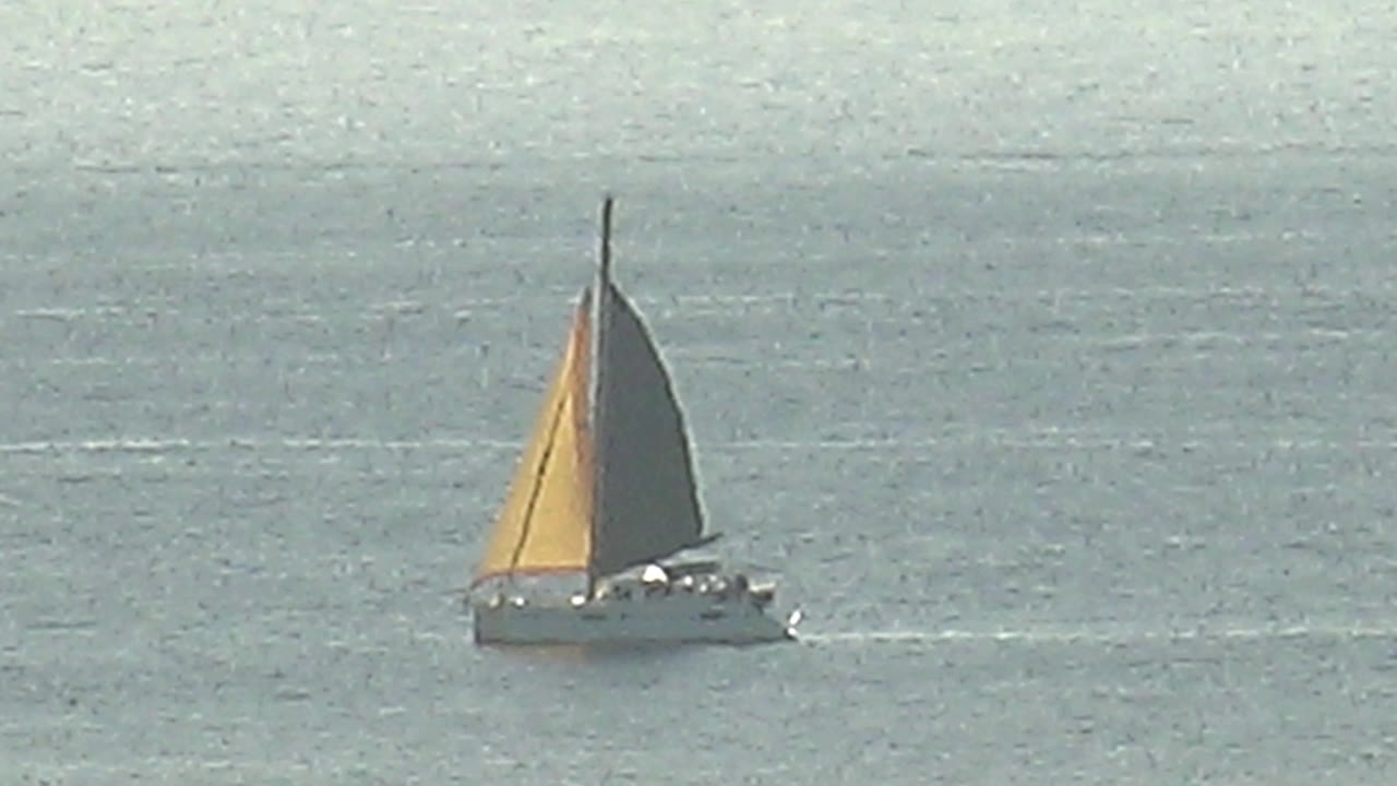 Sailboat on open water under a high horizon