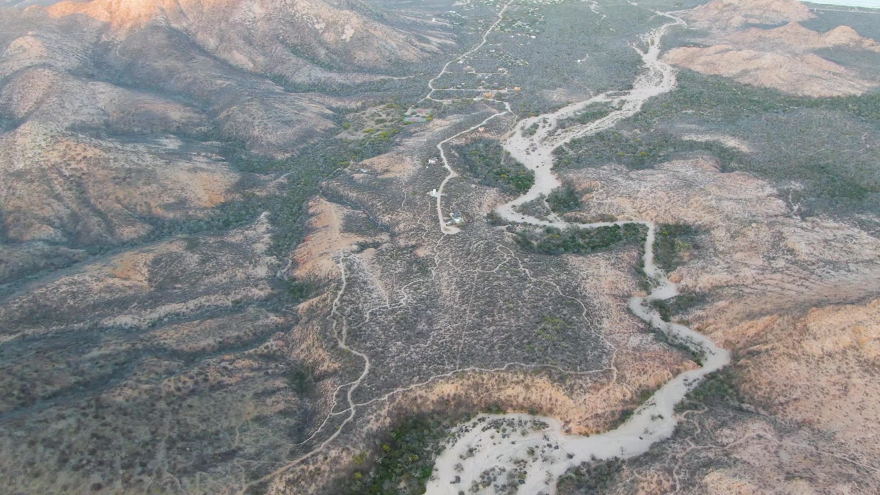 Aerial landscape with dirt road through arid ridges