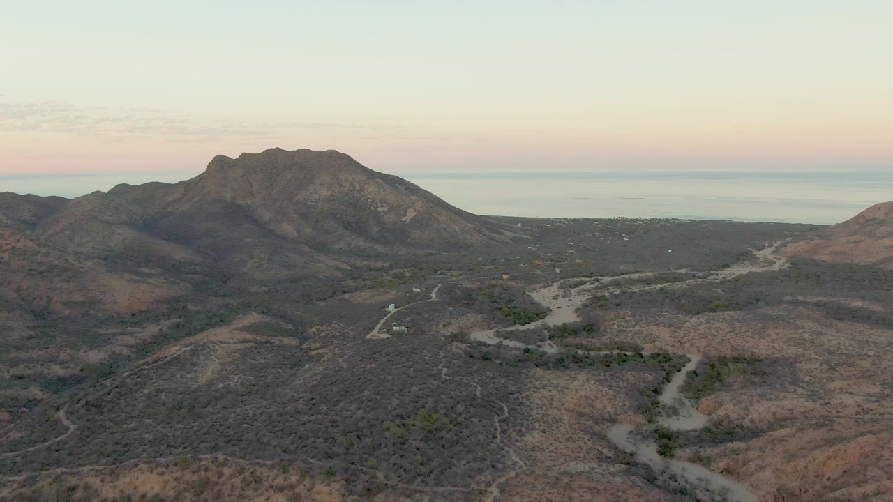 Midway across the first row, the Cabo Pulmo landscape shows dry ridges in the foreground, a branching dirt road in the midground, a rocky mountain beyond, and no visible people.