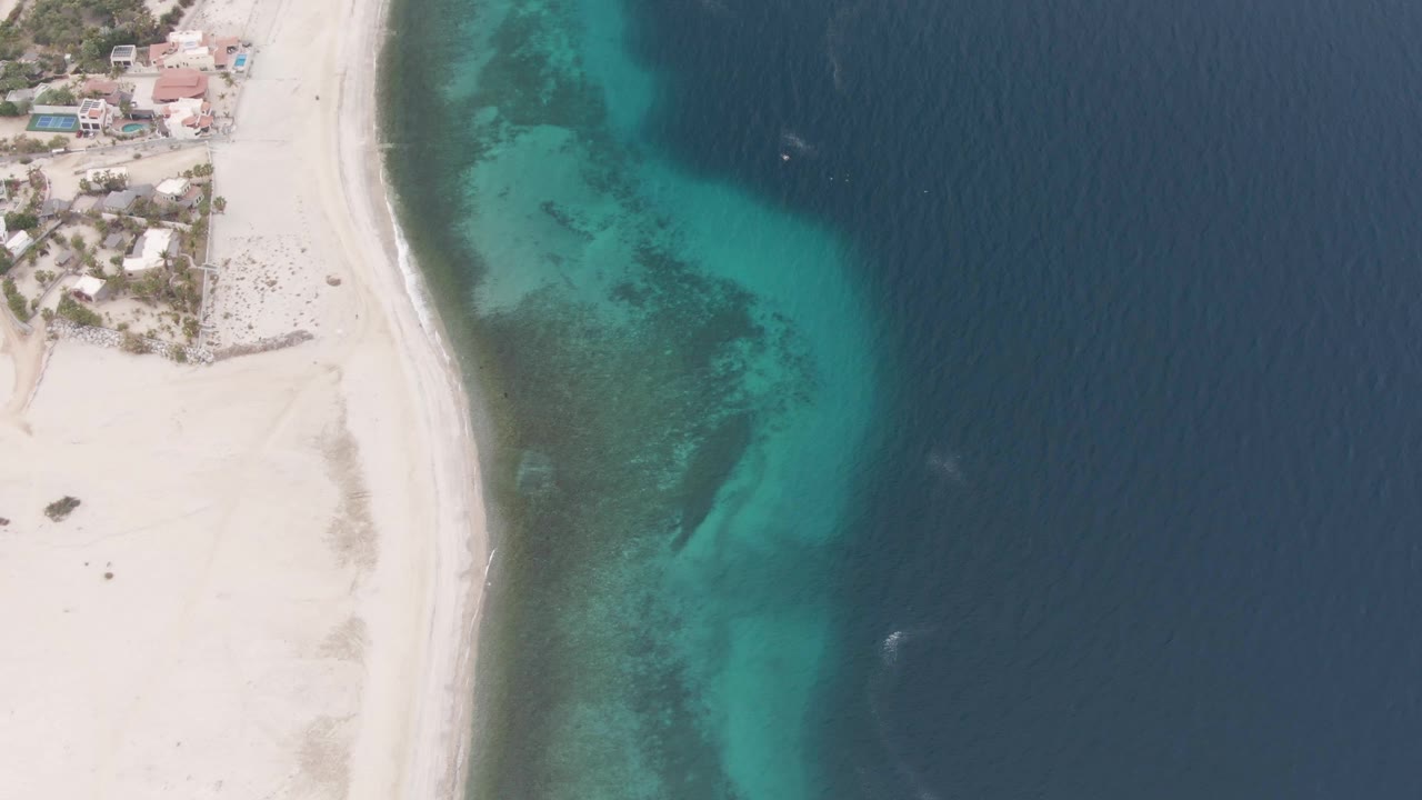 Drone view of curved sand beach and clear turquoise shallows