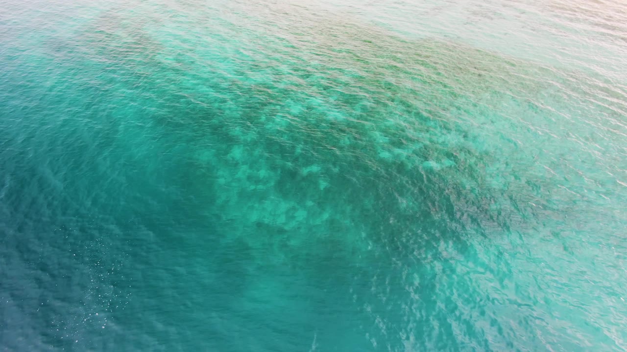 Shallow turquoise water with reef texture and brighter rippled surface