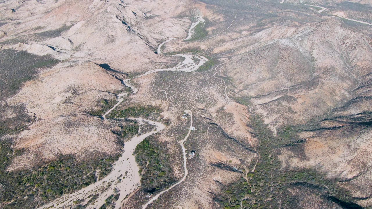 Winding dirt road descending through dry mountain terrain