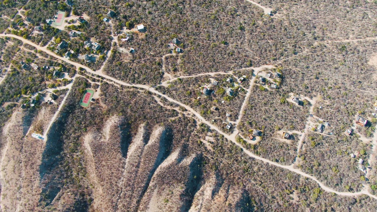 Aerial view of dirt roads through a dry residential hillside
